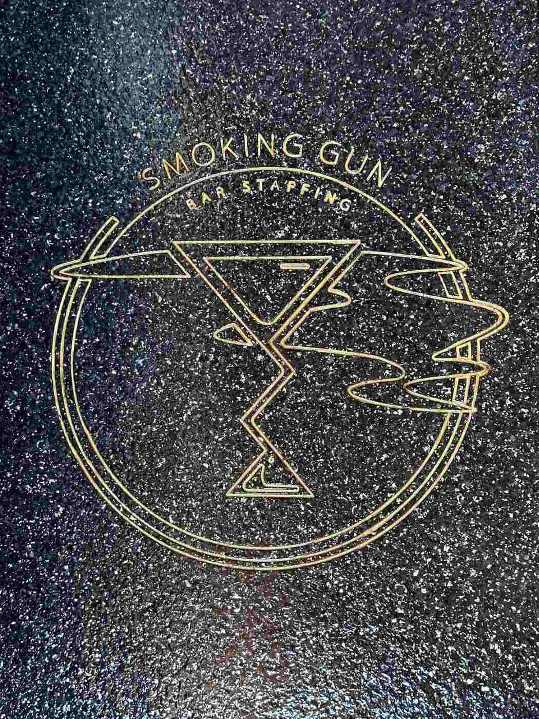 Smoking Gun bar logo engraved into dark polished concrete